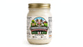 A glass jar of Condensedable Sweetened Creamery Sugar Free Vanilla Flavor Condensed Milk with a gold metal lid and a colorful cartoon cow label, set against a plain white background.